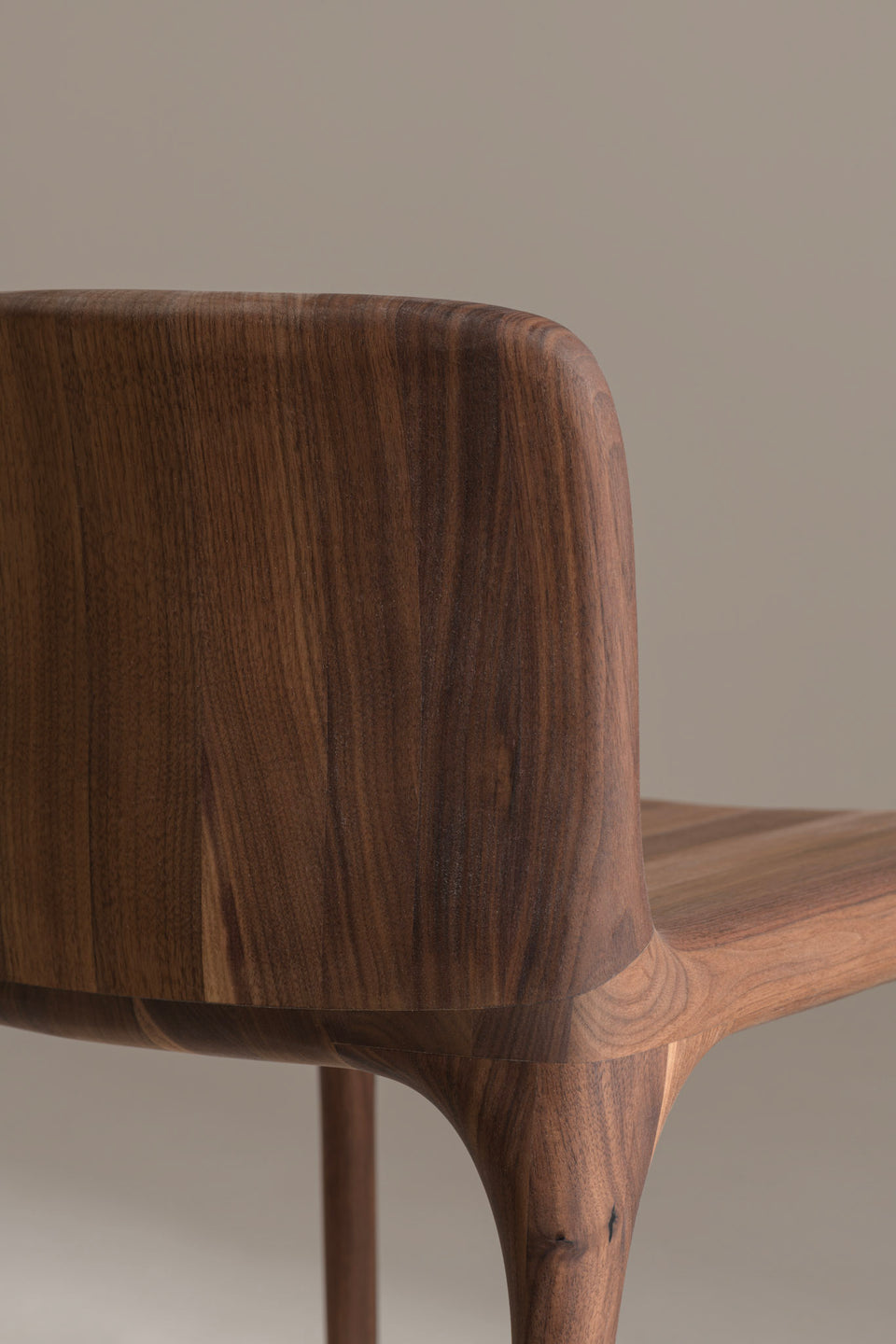 The seat and back are shaped from solid wood to provide support while maintaining a compact, minimal form.